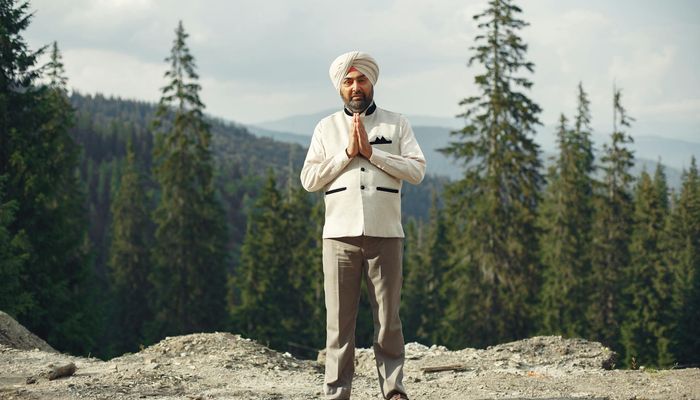 Person meditating peacefully outdoors with a natural green background.